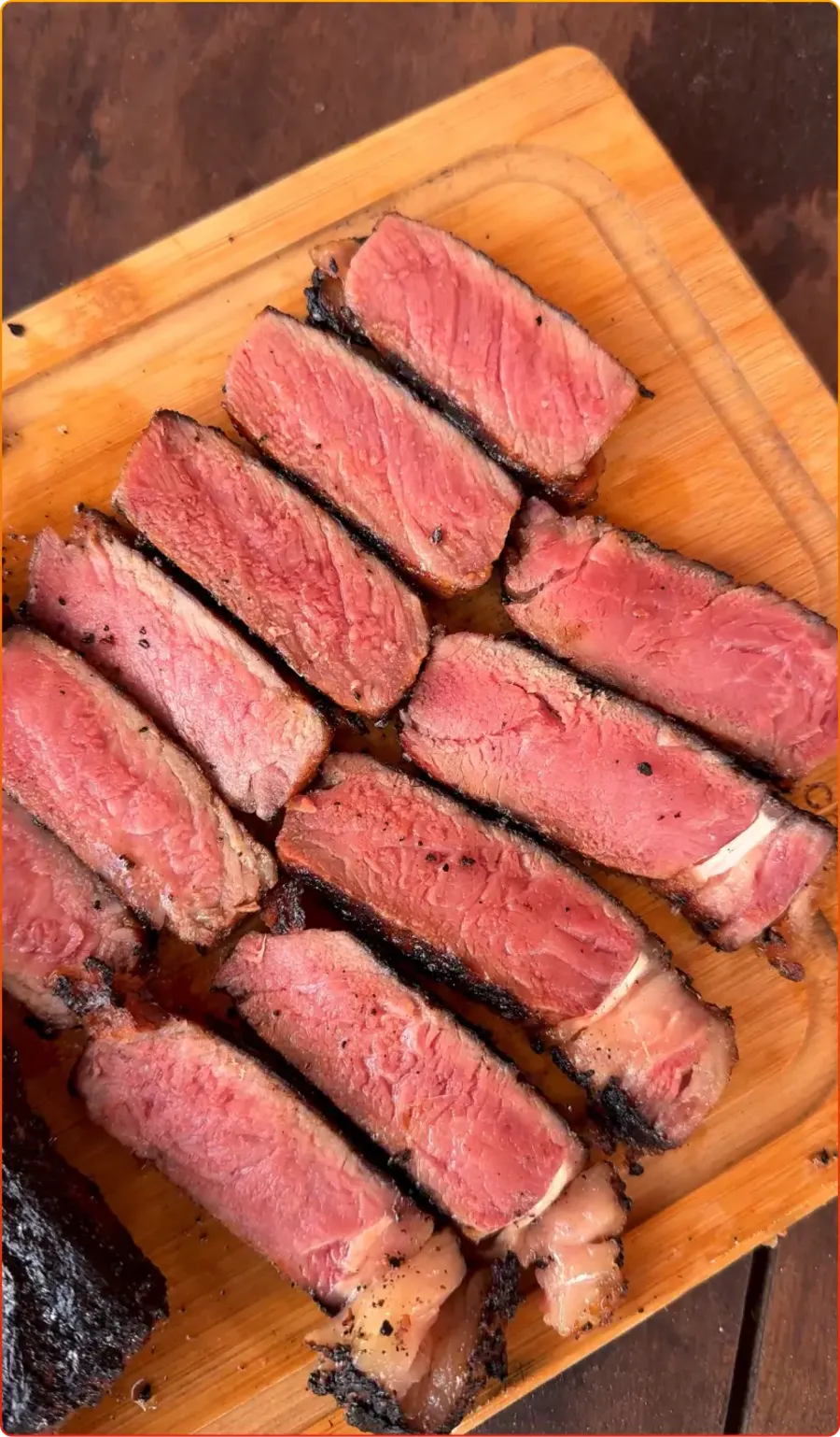 Picanha fatiada no ponto sobre tábua de madeira